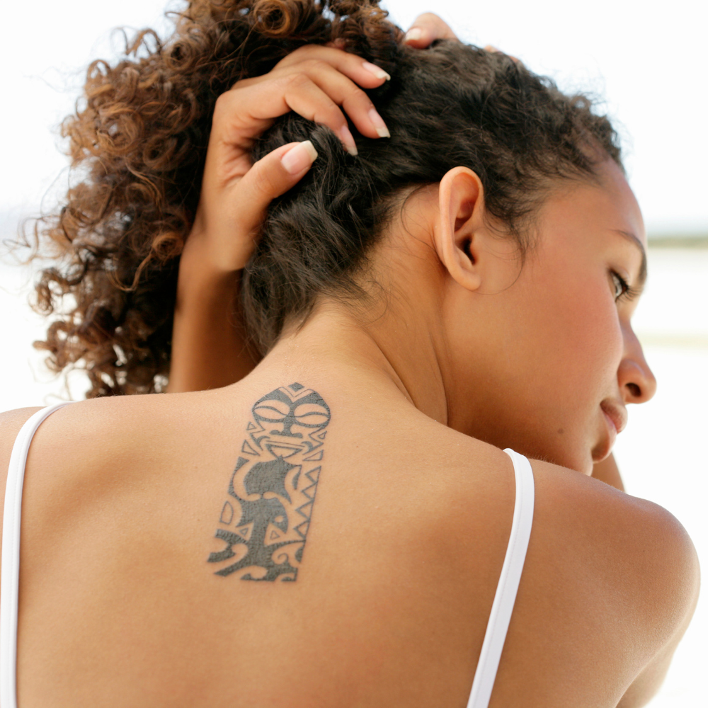 woman's back with polynesian-inspired tattoo