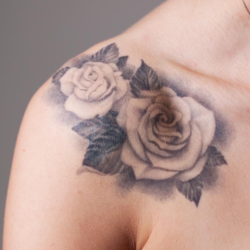 woman's shoulder with rose tattoo
